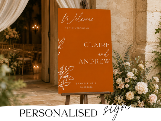 Burnt orange wedding welcome sign displayed on a wooden easel